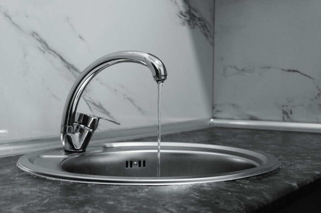 A potted houseplant draining in a sink after watering