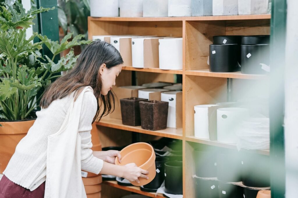 A nursery pot lifted from a ceramic planter showing trapped water at the bottom