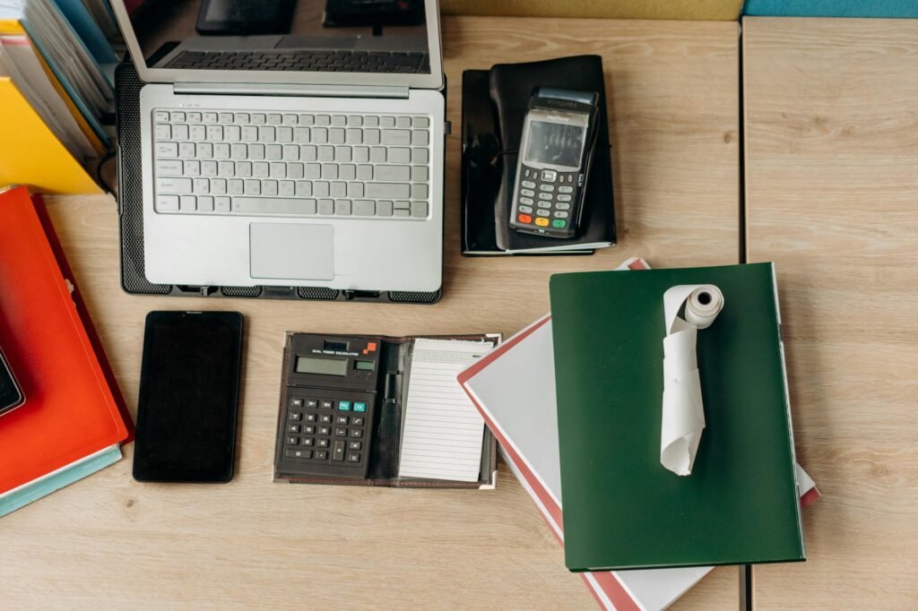 A neatly organized desk with a notebook, humidity meter, and a houseplant for tracking care changes.